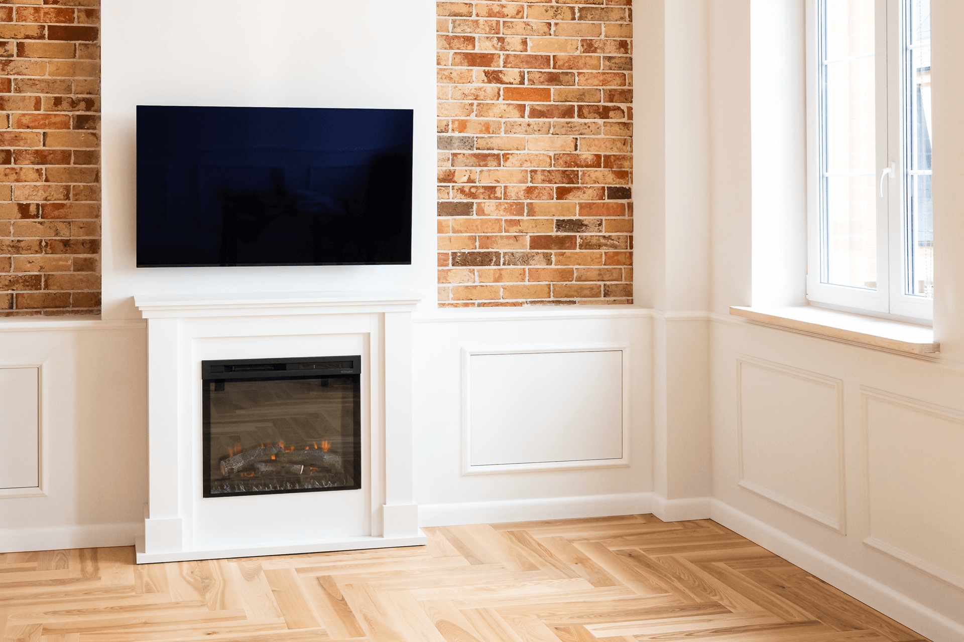 Fernsehwand in Weißt mit Kontrast zu Ziegelsteinoptik und Holzparkett
